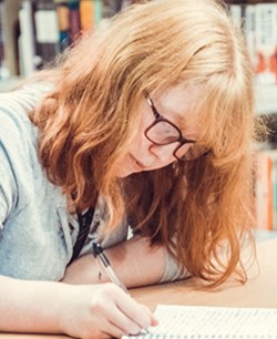 Girl writing in book at Gosforth Academy