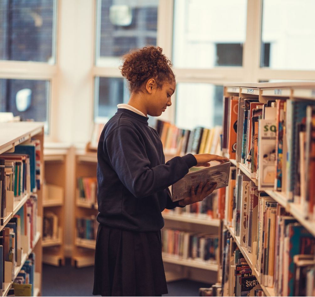 School pupil browses books in the library